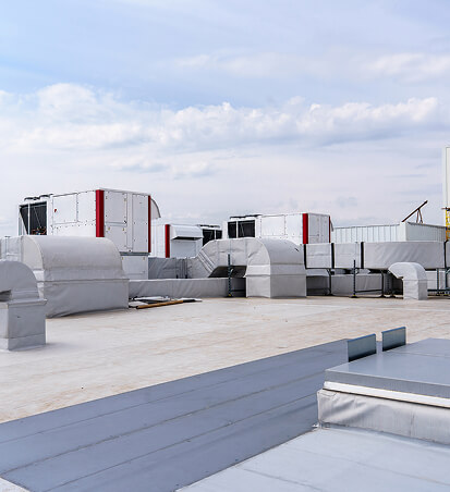 Commercial rooftop HVAC units under a cloudy sky