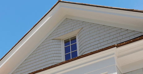 Close-up of a house gable with shingle siding and small window
