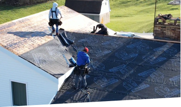Roofers installing new roofing material on a residential home
